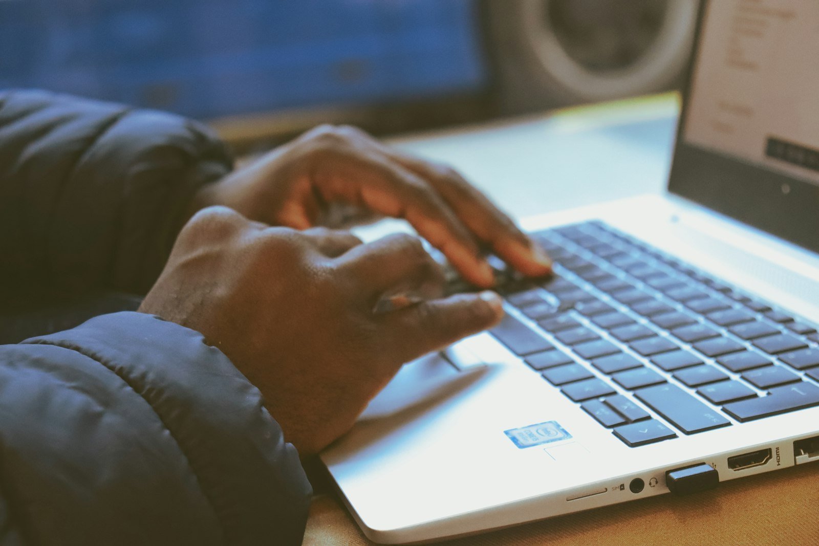 A person typing on a laptop keyboard