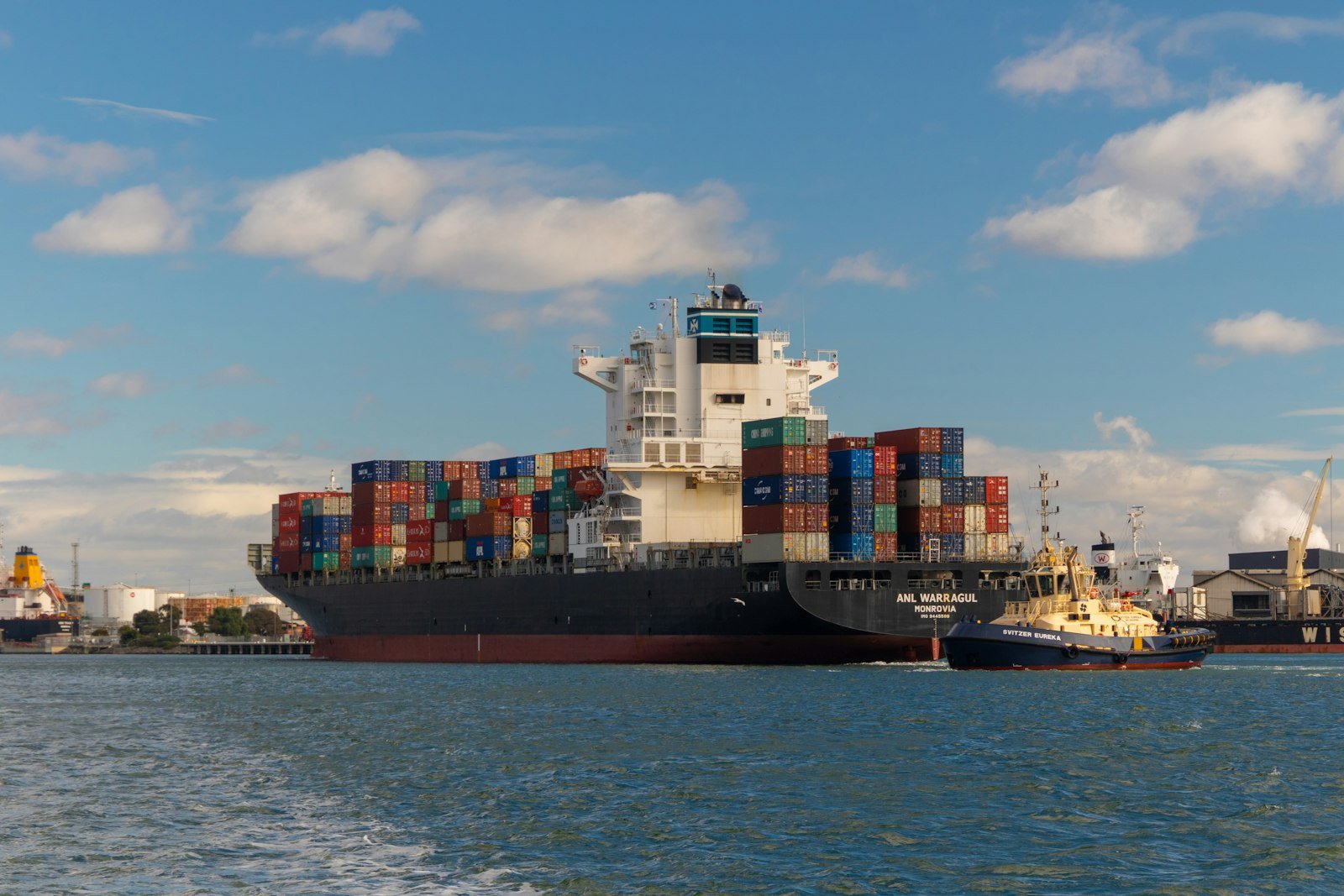 A cargo ship crossing the open sea under a clear blue sky